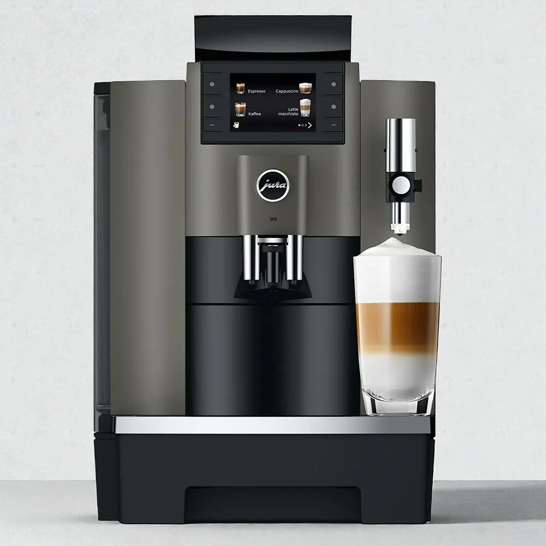 Jura W8 coffee machine with a glass of layered coffee on a light gray background